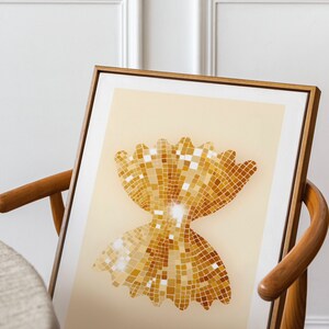 May include: A framed print of a gold bow tie pasta shape made of small squares, resembling sequins. The pasta is on a light beige background.