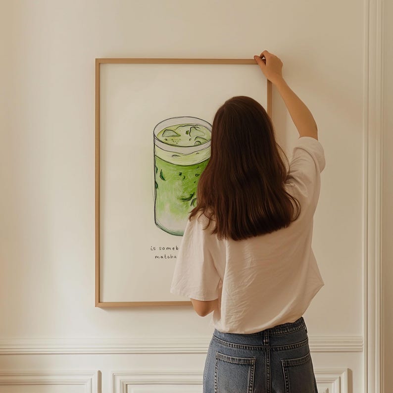 May include: A framed illustration of a glass of iced matcha with the text "Le someb matcha" below it.