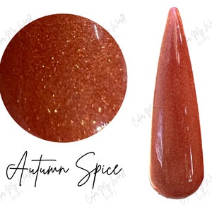 May include: A close-up of a small jar of shimmery orange nail polish with a label that reads "Autumn Spice".