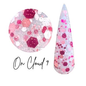 May include: A nail dip sample and a nail tip, both filled with pink, white, and burgundy glitter. The text "On Cloud 9" is written in black script. The glitter is in various shapes and sizes.