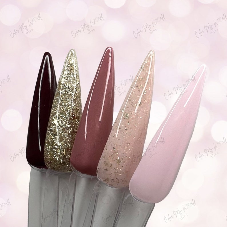 May include: Five different nail polish colors in a row. The colors are burgundy, gold glitter, rose gold, light pink with gold glitter, and light pink.