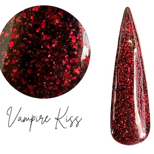 May include: A close-up of a nail with a dark red glitter polish. The polish is a deep burgundy color with red glitter flecks. The words "Vampire Kiss" are written in cursive below the nail.