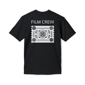 May include: Black t-shirt with a white graphic design on the back. The graphic features a film crew test pattern with the text "FILM CREW" above it.