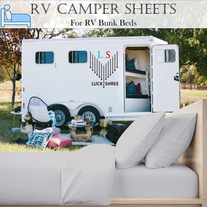 May include: White RV camper with bunk beds and the text "RV CAMPER SHEETS For RV Bunk Beds" on the side. The camper is parked in a grassy area with a white bed with two pillows in the foreground.