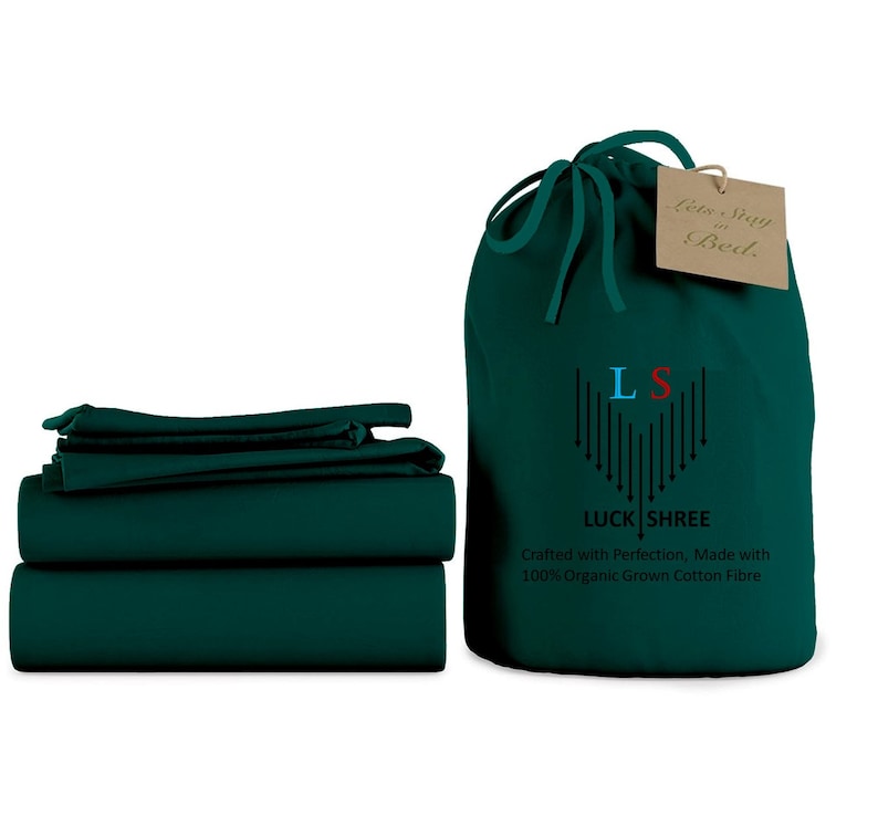 May include: A set of dark green bed sheets folded neatly, with a matching drawstring bag. The bag has the text "Lets Stay in Bed" and the logo "LS" for "Luck Shree" with the text "Crafted with Perfection, Made with 100% Organic Grown Cotton Fibre".