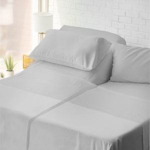 May include: A white bed with a white fitted sheet, a white flat sheet, and two white pillowcases. The bed is made with crisp, clean linens.