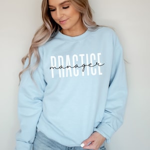 May include: Light blue sweatshirt with the text "PRACTICE manager" in white lettering.