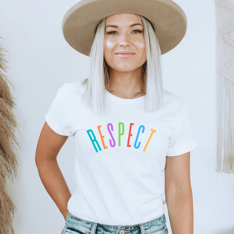 May include: A white t-shirt with the word "RESPECT" printed in rainbow colors.