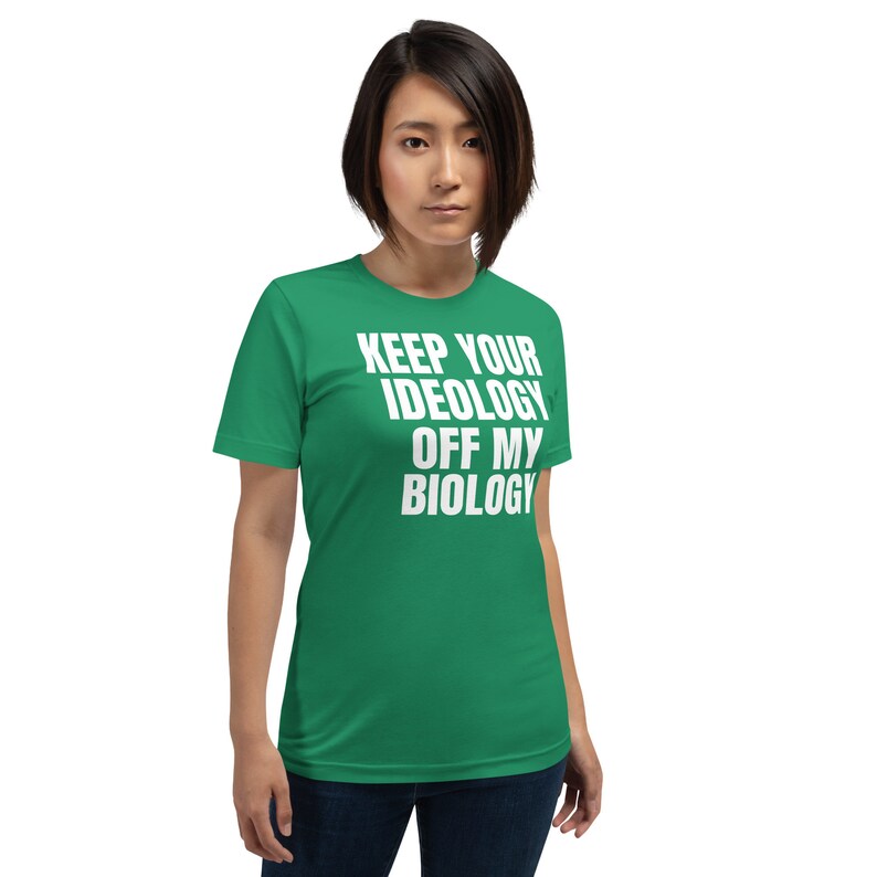 May include: A green t-shirt with white text that reads "Keep Your Ideology Off My Biology".