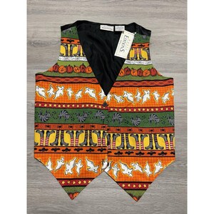 May include: A Halloween-themed vest with a black back and a colorful patterned front. The front features orange, green, and yellow stripes with ghosts, pumpkins, cats, and witch boots. The word "Happy" is visible. A tag reads "Basic Editions."