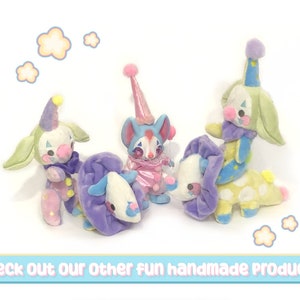 May include: A collection of handmade plush clown figures in various poses. The clowns feature pastel colors, including blue, green, pink, and purple, with whimsical details like pom-poms and patterned clothing. The image includes the text: "Check Out Our Other fun handmade products!"