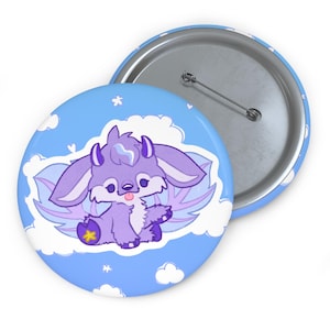 May include: A round pin-back button featuring a cartoon illustration of a purple creature with large ears, horns, and wings sitting on a white cloud against a light blue sky with small white clouds and hearts. The back shows a metal pin mechanism.