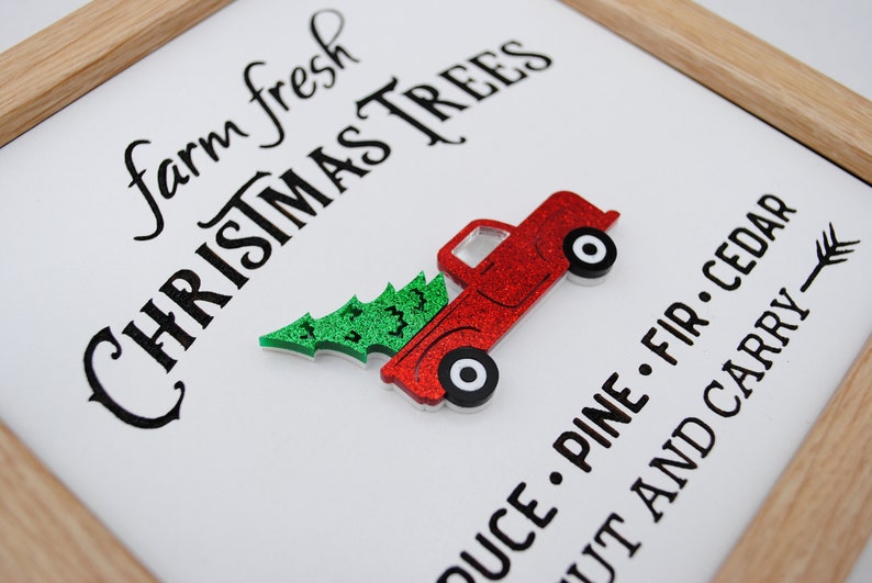 Puede incluir: Un cami&oacute;n rojo con un &aacute;rbol de Navidad verde en la parte trasera, con el texto "farm fresh CHRISTMAS TREES" y "OUCE. PINE. FIR. CEDAR UT AND CARRY" sobre un fondo blanco.