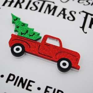 Puede incluir: Una camioneta roja con un &aacute;rbol de Navidad verde en la caja. La camioneta est&aacute; hecha de purpurina y tiene ruedas blancas. El texto "Fresh Christmas Tree" es visible en el fondo.