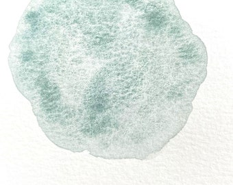 May include: A light blue watercolor painting of a circle with the word "CENOTE" written in black below it.