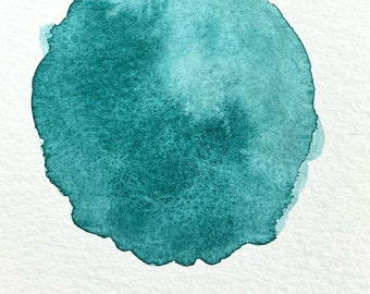 May include: A teal watercolor painting of a circle with the word "YUCATÁN" written in black below it.
