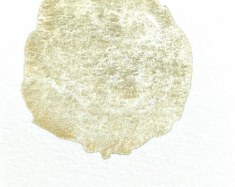 May include: A gold-colored circle painted on a white background with the text "EX-VOTO" written below.