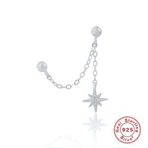May include: Silver star charm earring with a chain connecting to a second stud. The star has small clear stones and the chain is delicate. The earring is marked "Real Sterling 925 Silver".