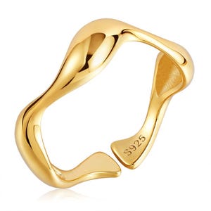 May include: A gold-coloured, open-ended ring with a fluid, organic design. The ring has a wavy, asymmetrical shape and a polished finish. The interior of the ring is visible, and the band is marked with "S925".