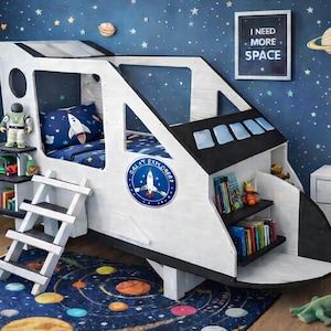 May include: A white and black spaceship-shaped bed frame with a ladder, shelves, and a blue and white rocket ship-themed bedding set. The bed is in a room with a starry night sky wallpaper and a rug with planets.