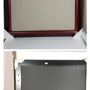 May include: A rectangular picture frame with a burgundy-colored border and a neutral-colored interior. The frame is packaged in a white cardboard box with white corner protectors. The back of the frame is black.