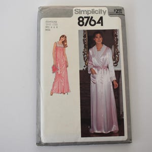 May include: Simplicity 8764 sewing pattern. The pattern envelope features illustrations of a pink satin nightgown and robe. The envelope is white with black text and a price tag in the upper right corner. The pattern includes sizes 6 & 8.