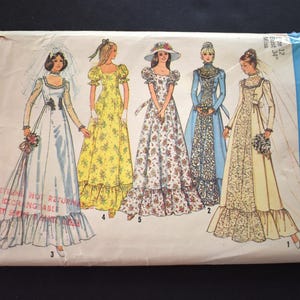 May include: Vintage Simplicity sewing pattern envelope featuring illustrations of five different wedding dresses. The dresses are in various styles, including a long-sleeved gown with a veil and a floral print dress. The envelope has a blue and white design.