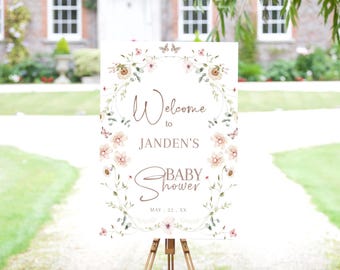 May include: A white welcome sign with a floral wreath border and the text "Welcome to Janden's Baby Shower May 22, XX".