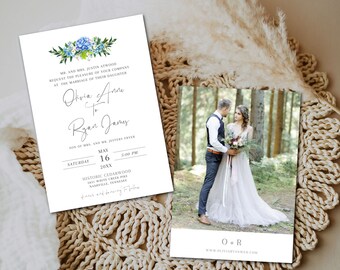 May include: A wedding invitation with blue and green floral accents. The invitation is for Olivia and Ryan's wedding on May 16th, 20XX at 5:00 PM at Historic Cedarwood, 2612 White Creek Pike, Nashville, Tennessee. The invitation includes a photo of the couple in a forest setting.