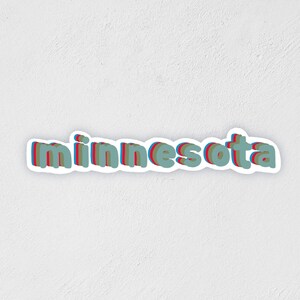 May include: A sticker with the word "minnesota" in a 3D style with red, blue, and green colors.