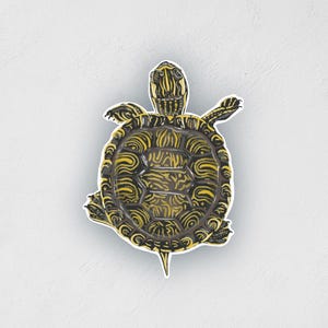 May include: A yellow and black turtle with a patterned shell. The turtle is facing the camera with its head and legs visible.