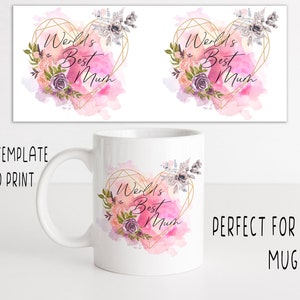 May include: White ceramic mug with a pink watercolor heart design. The heart has a gold geometric outline and floral accents. The text "World's Best Mum" is inside the heart.