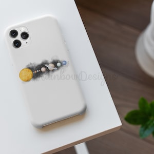 May include: White phone case featuring a watercolour illustration of the solar system. The sun is yellow, the planets are blue, green, and brown, and the background is black.