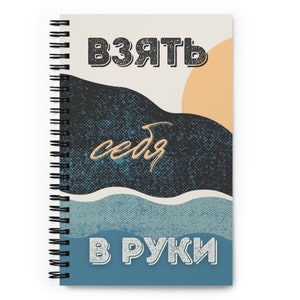 May include: A spiral bound notebook with a beige background and a blue, black, and orange abstract design. The text "Взять себя в руки" is printed in white on the cover.