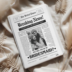 May include: A black and white newspaper-style card with the headline "Breaking News!" and the text "I can't say I do without you!"  The card features a photo of two women and the text "Ava, will you be my bridesmaid?"