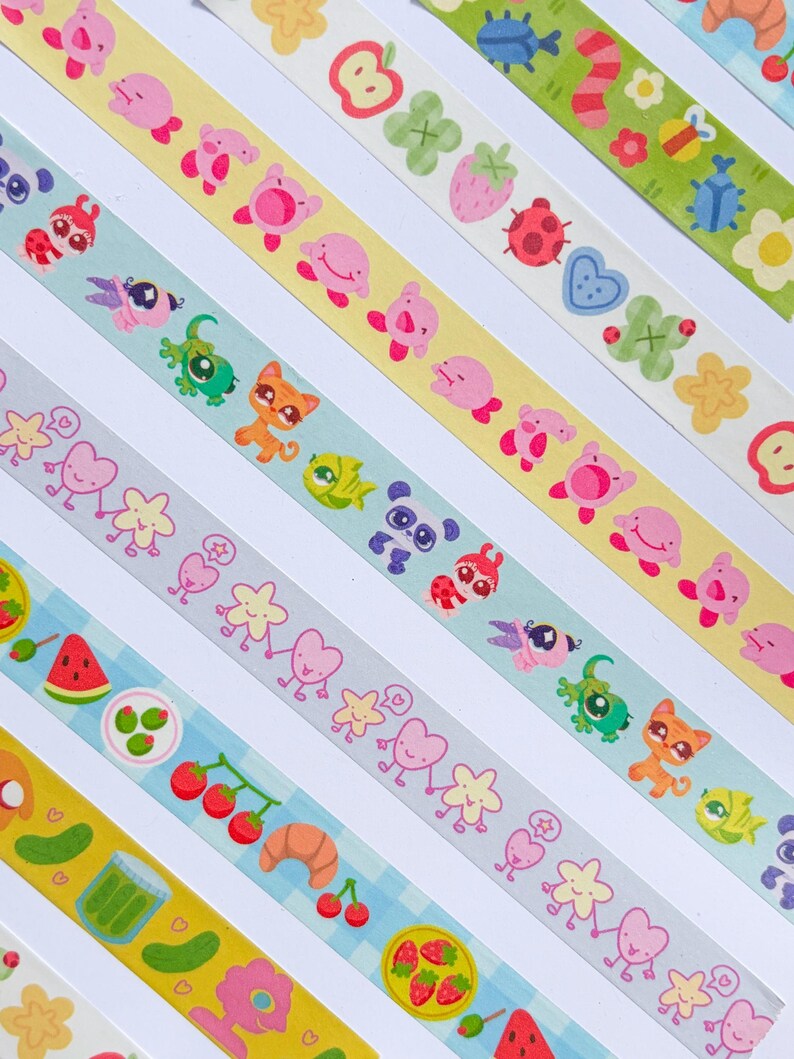 Puede incluir: Una colecci&oacute;n de cintas washi coloridas con varios patrones. Los dise&ntilde;os incluyen animales de dibujos animados, frutas, flores y alimentos. Las cintas est&aacute;n dispuestas en diagonal, mostrando una variedad de colores e ilustraciones.