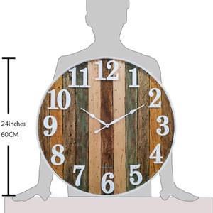 May include: A large, round, 24-inch diameter, wooden wall clock with white Roman numeral markings and a white frame. The clock face has a distressed wood design with a variety of wood tones, including brown, tan, and green.