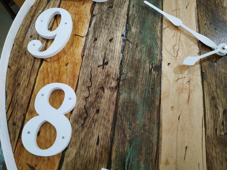 May include: Close-up of a wooden clock face with white numbers 8 and 9. The clock hands are white and point to the right.