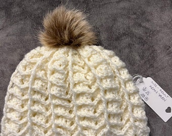 Gorro para adulto con pompón desmontable y etiqueta hecha a mano. Tejido a ganchillo con hilo acrílico de grosor Aran o Aran.