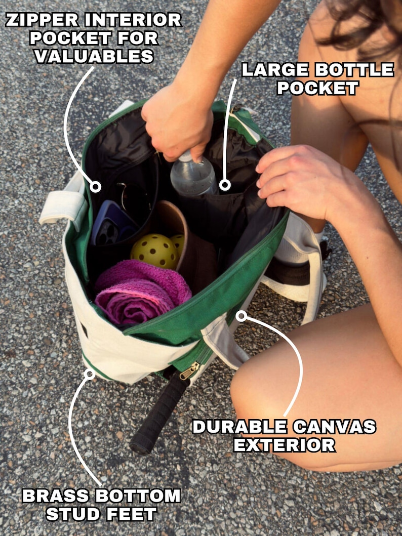 Peut inclure: Un sac fourre-tout en toile vert et blanc avec une poche int&eacute;rieure zipp&eacute;e, une grande poche pour bouteille et des pieds en laiton. Le sac est rempli de divers articles, dont une bouteille d'eau, une serviette rose et quelques balles.