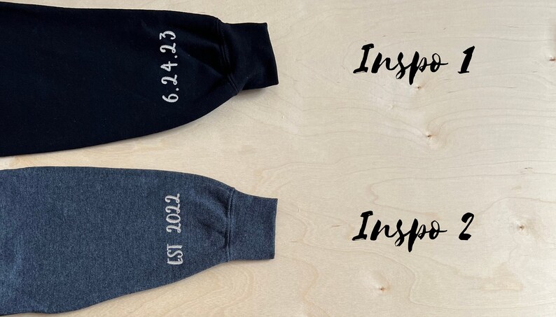Op de afbeelding: Twee sweatshirtmouwen met witte borduursels. De zwarte mouw heeft de tekst "6.24.23" en de grijze mouw heeft de tekst "EST 2022".