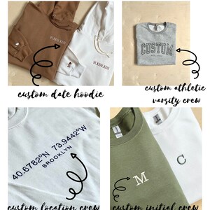 Op de afbeelding: Vijf verschillende geborduurde sweatshirts met verschillende ontwerpen. De sweatshirts zijn in verschillende kleuren, waaronder bruin, wit, grijs, lichtblauw en groen. De ontwerpen omvatten een datum, een locatie, initialen en het woord "CUSTOM".
