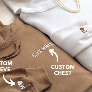 Custom date, English text, words, or phrase on chest shown. We will convert it to roman numerals if the date is provided as a standard date format. Personalized initial example with heart on sleeve shown for both hoodies pictured for matching couple.