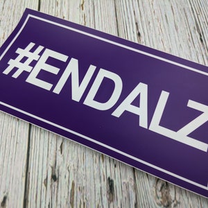 May include: Purple sticker with white text that reads "#ENDALZ".