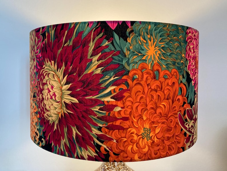 May include: A lampshade with a floral print featuring large, vibrant red, orange, and green chrysanthemums on a black background.