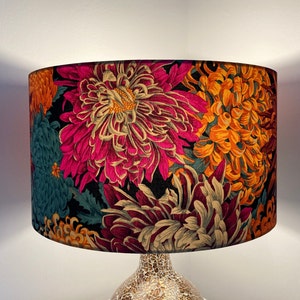 May include: A lampshade with a floral pattern in shades of pink, orange, teal, and cream. The flowers are stylized and resemble chrysanthemums.