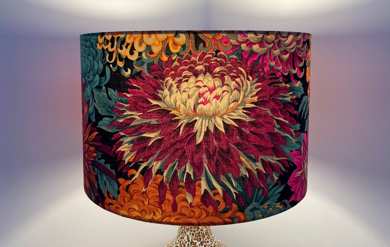 May include: A black lampshade with a floral pattern featuring large, vibrant pink, yellow, and orange flowers on a dark background.