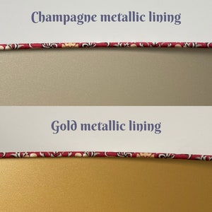 Op de afbeelding: Twee close-up afbeeldingen van een stoffen bies met een bloemenpatroon. De bovenste afbeelding toont een champagnekleurige metallic voering. De onderste afbeelding toont een gouden metallic voering.