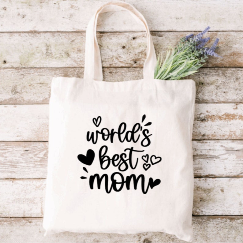 May include: White canvas tote bag with black text that reads "world's best mom" with hearts around the text.