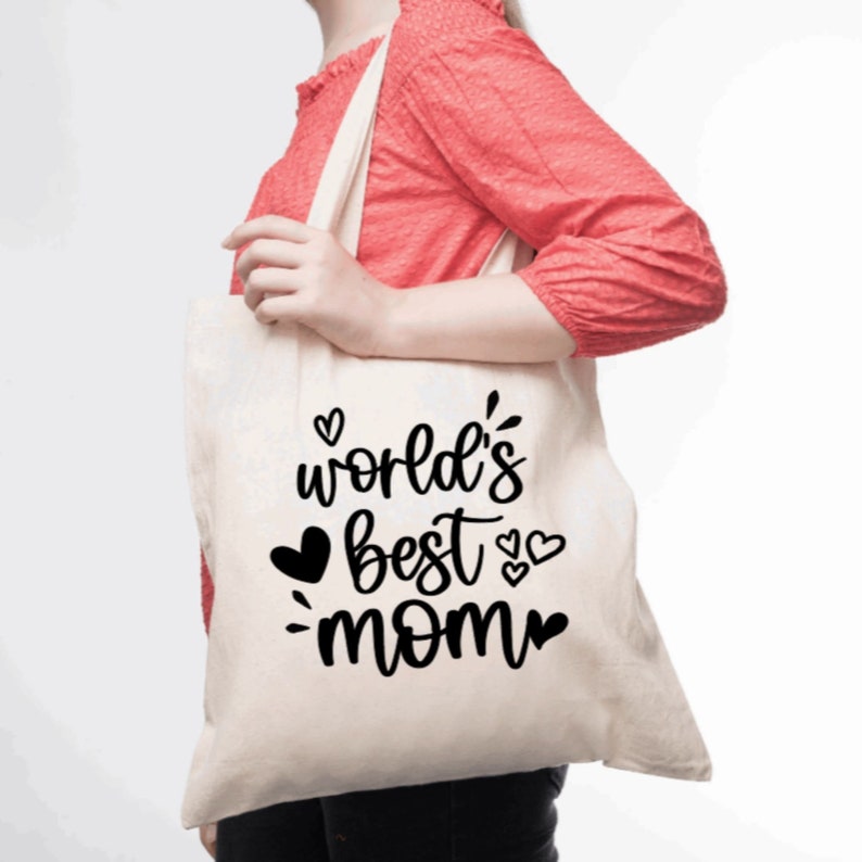 May include: A white canvas tote bag with black text that reads "world's best mom" with hearts around the text.